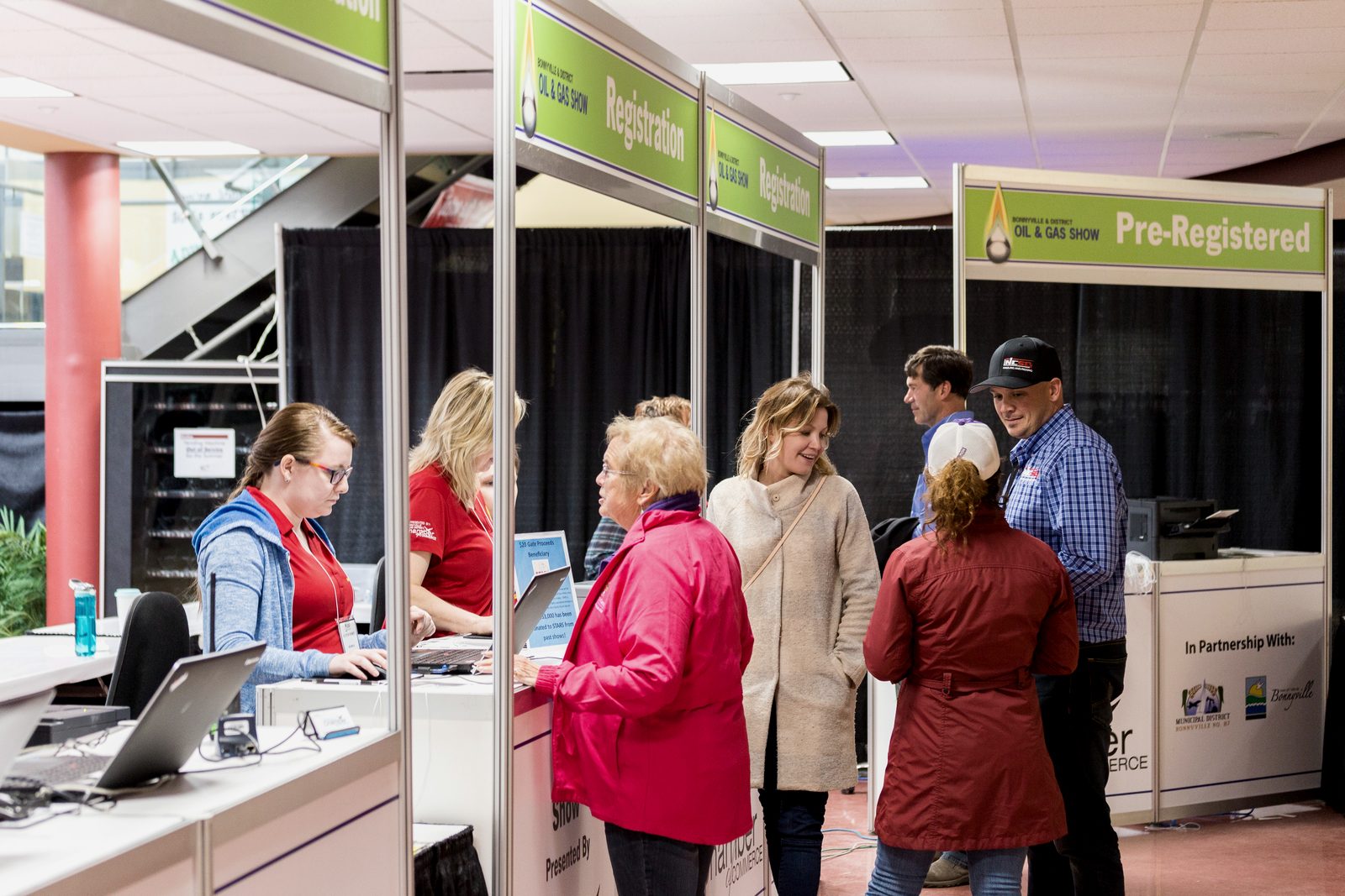 Exhibitors welcoming visitors at a trade show booth